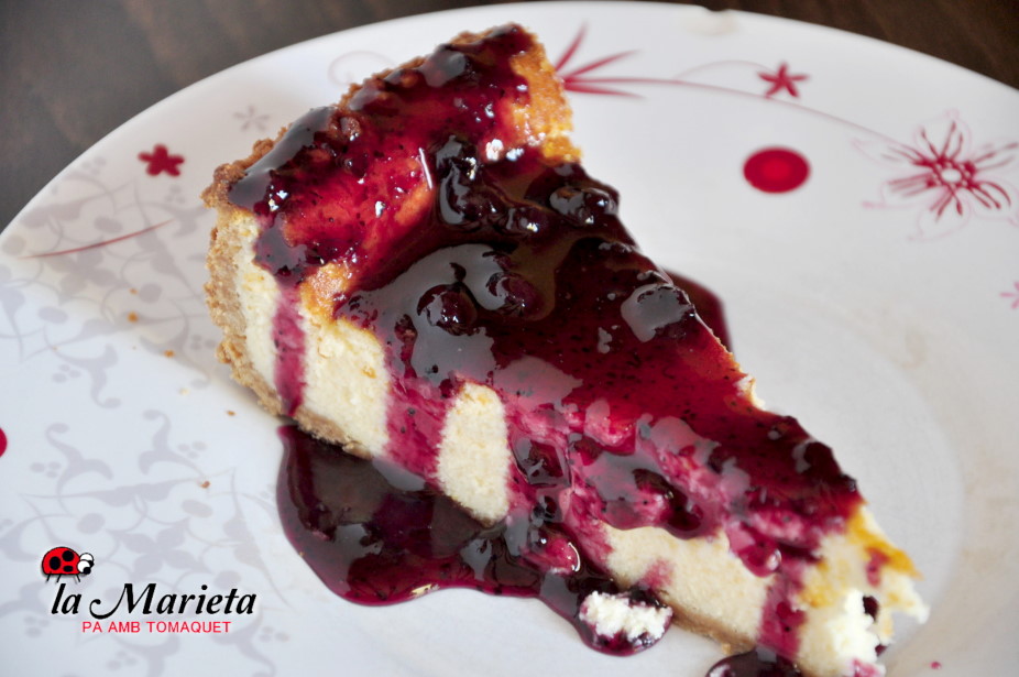 Ración de tarta de queso con mermelada de arándanos