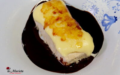 Helado de turrón cubierto de crema y rodeado de chocolate