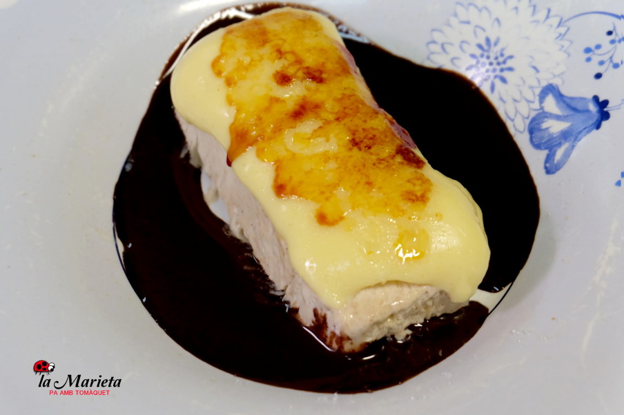 Helado de turrón cubierto de crema y rodeado de chocolate